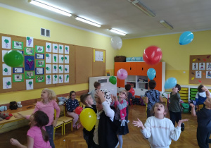 Grupa dzieci bawi się balonami