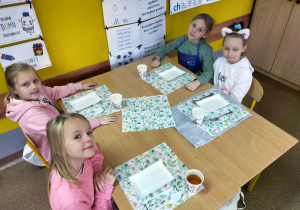 Grupa dziewczynek przy nakrytym stole