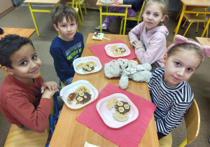 Grupa uczniów przy stole z misiowymi kanapkami