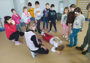 Grupa dzieci uczy się ułożenia w pozycji bocznej ustalonej.