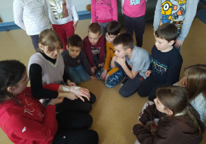 Grupa dzieci uczy się zakładania opatrunkuj.