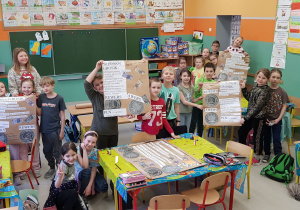 Dzieci prezentują plakaty Na planecie Grosik.