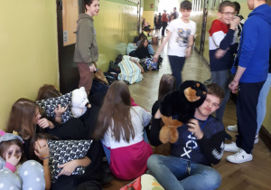 Uczniowie z przytulankami na korytarzu szkolnym