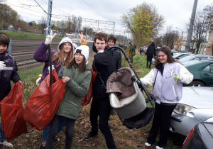 Grupa uczniów podczas zbiórki śmieci w parku