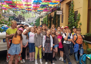 Gromada dzieci pod parasolkami.
