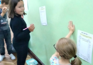 Uczniowie wykonują ćwiczenia na korytarzu szkolnym