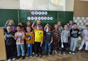 Uczniowie klasy 1b przed tablicą z napisem "Dzień Chłopaka"
