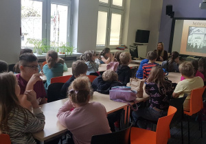 Uczniowie oglądają prezentację multimedialną o najstarszym filmie w Łodzi.