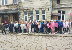 Uczniowie stoją przed budynkiem Gminy Żydowskiej.