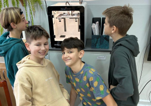 Czterech uczniów przed drukarką
