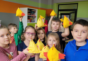 Grupa uczniów z żółtymi kurczaczkami w dłoniach