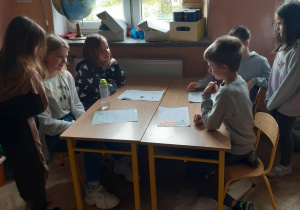 Uczniowie klasy 4a siedzą przy ławce