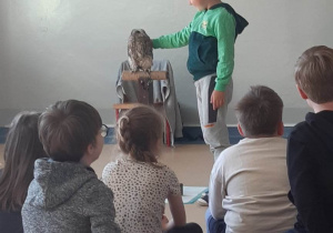 Uczeń głaszcze sowę.