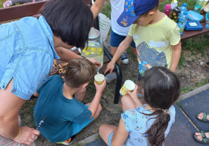 Dzieci nalewają lemoniadę do kubków