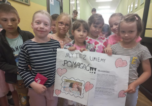 Grupa uczniów z plakatem "Pomagamy Igorowi"