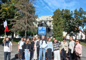 Uczniowie klas 7 i 6 pod pomnikiem św. Jana Pawła II