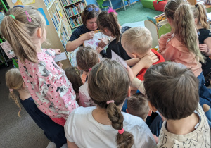 Uczniowie przypinają do tablicy ilustracje z oznakami wiosny