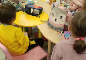 Uczniowie przy stolikach zjadają śniadanie